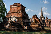 Thailand, Old Sukhothai - Wat Mahathat, square-based, multi-layered chedi with statues of seated Buddha at each side, stucco figures of lions and elephants decorate the base. 